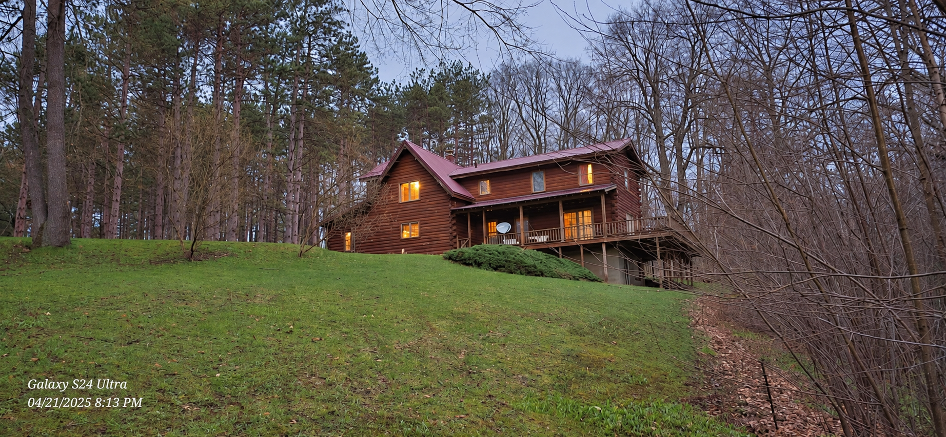 The real log cabin at dusk with warm windows