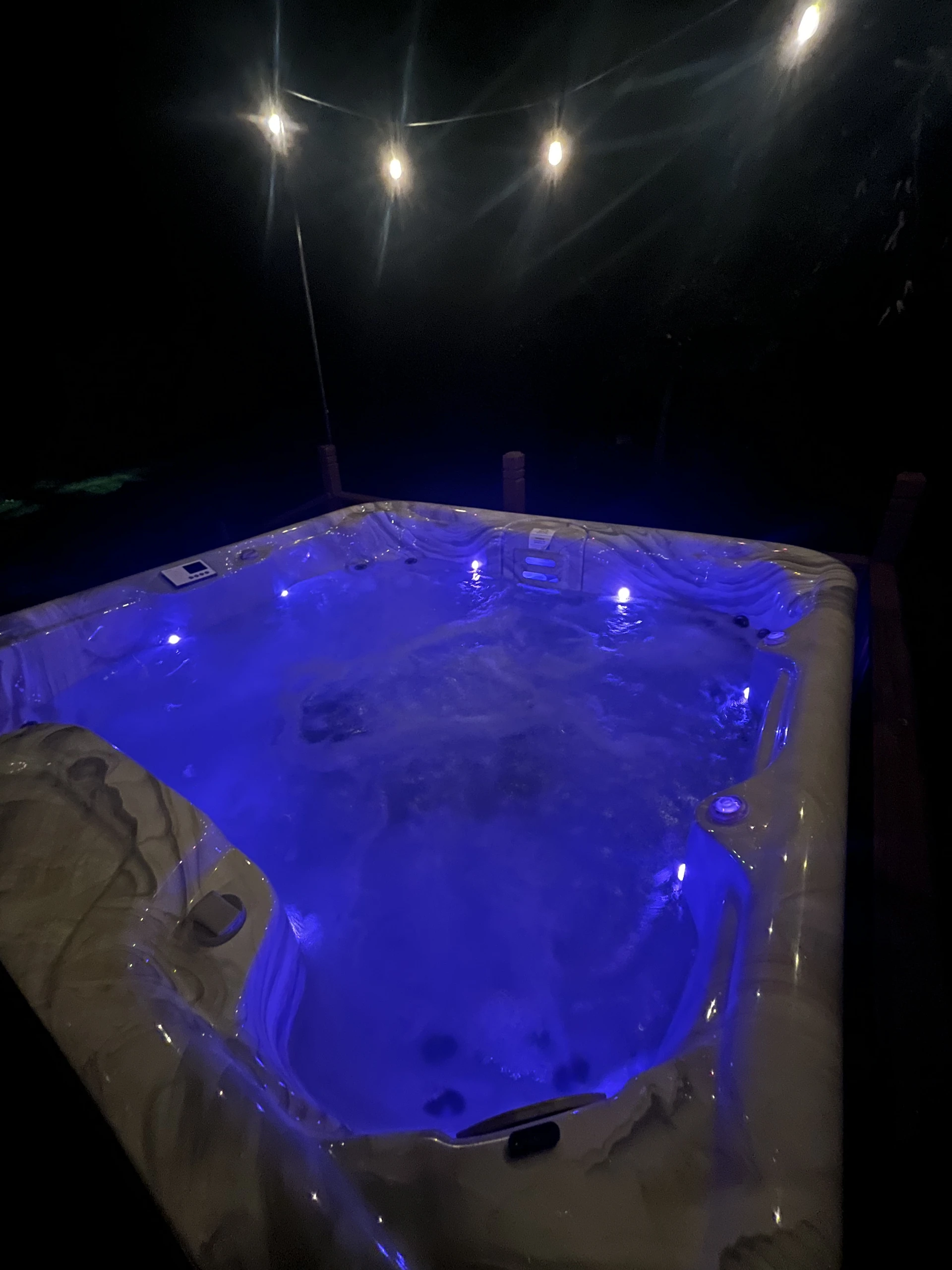 Blue-lit water in the outdoor hot tub